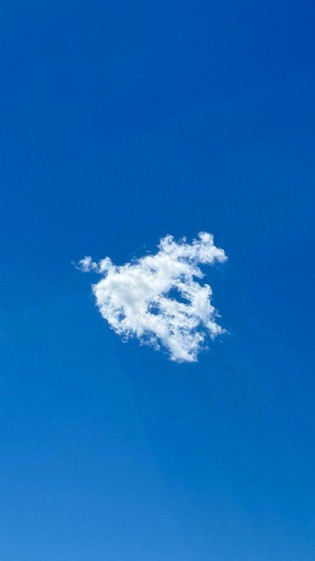 A single small cloud in a deep blue sky