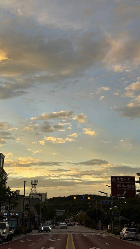 Broken golden clouds over a quiet town street at dusk