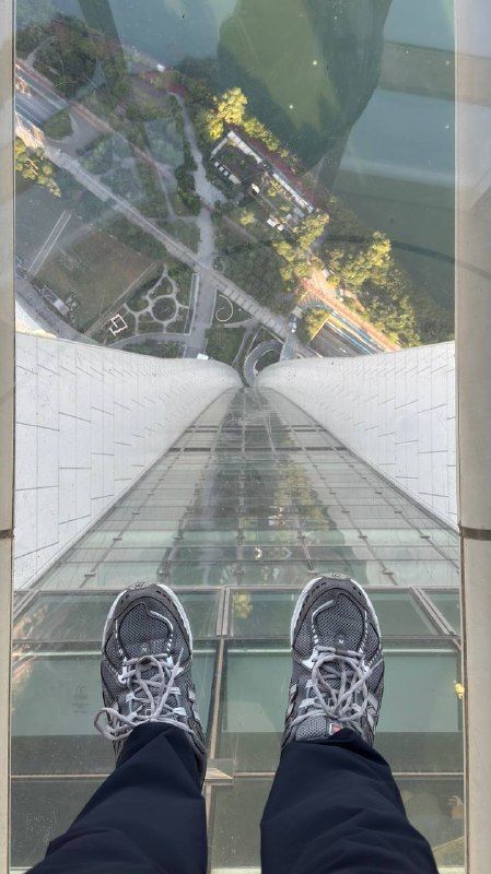 Sneakers on a glass floor high above the city