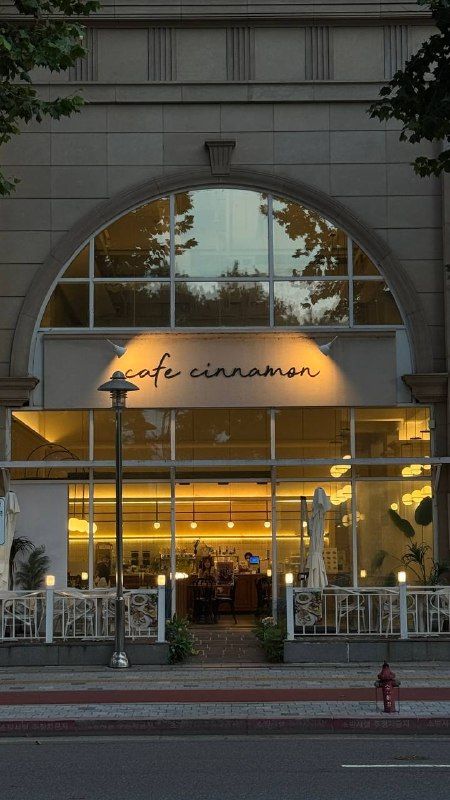 A café with warm-lit arched windows at dusk