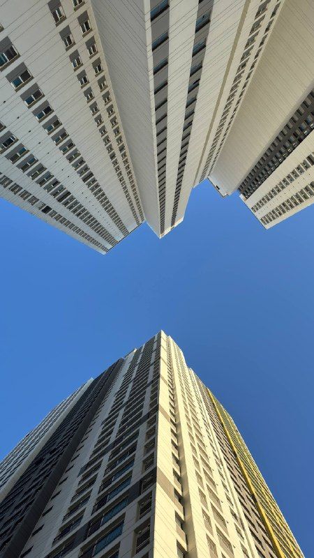 Looking straight up between two apartment towers into blue sky